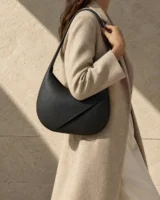 Aural Crescent Shoulder Bag in ink worn with a tailored outfit