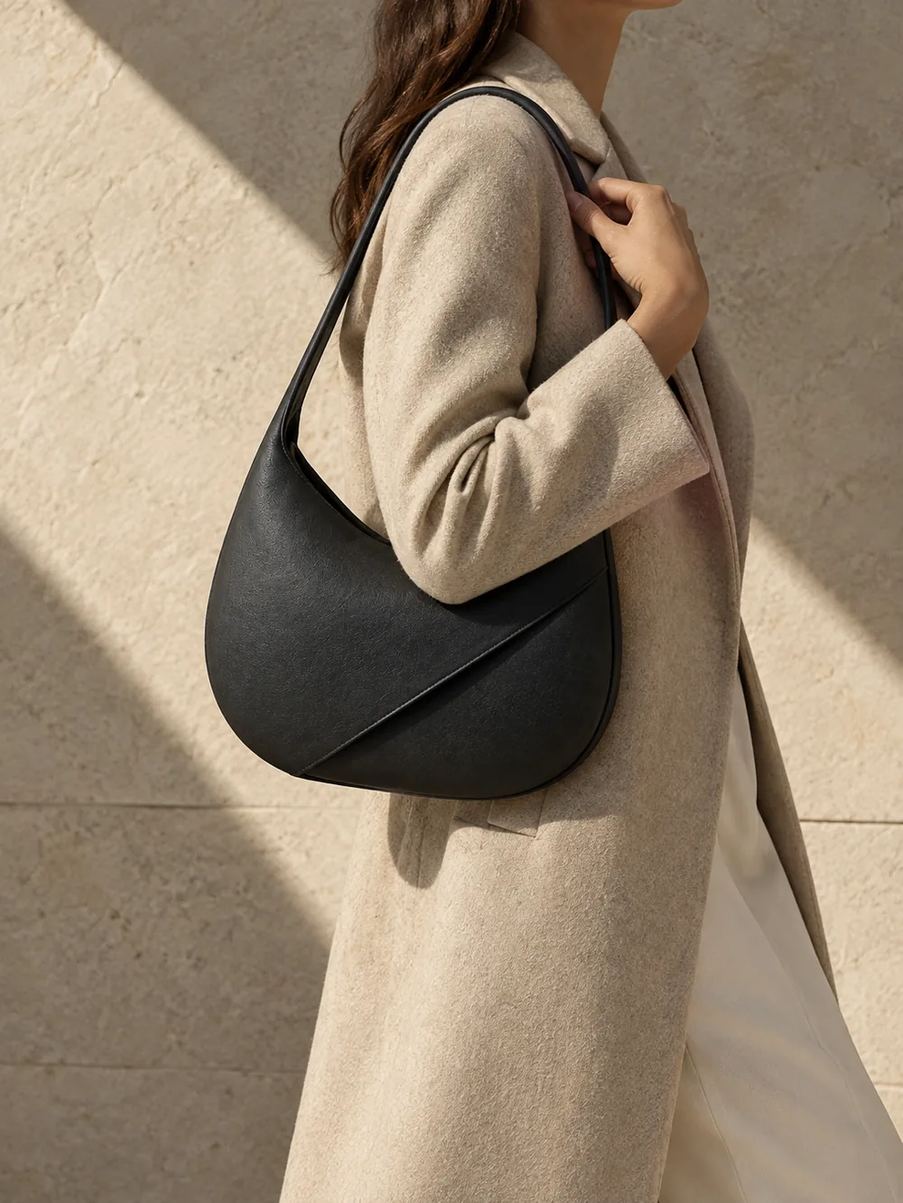 Aural Crescent Shoulder Bag in ink worn with a tailored outfit