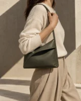 Vela Ridge Shoulder Bag in olive worn with a tailored outfit