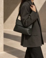 Hinge Shoulder Bag in deep forest worn with a tailored outfit