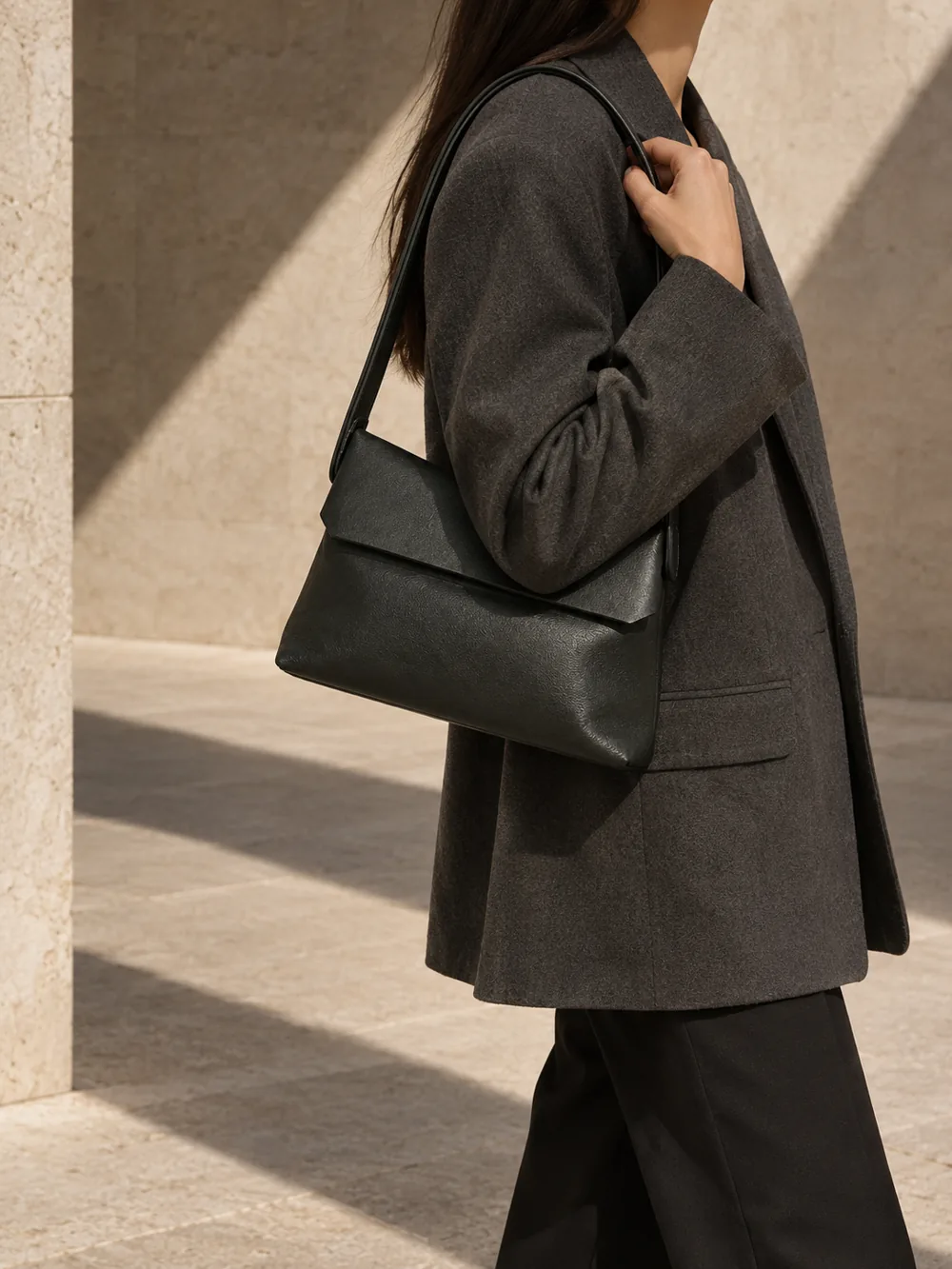 Hinge Shoulder Bag in deep forest worn with a tailored outfit