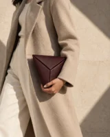 Triad Triangle Clutch in oxblood worn with a tailored outfit