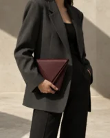 Lamina Double-Edge Clutch in oxblood worn with a tailored outfit