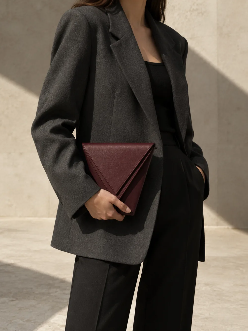 Lamina Double-Edge Clutch in oxblood worn with a tailored outfit