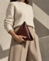 Apex Triangle Clutch in oxblood worn with a tailored outfit