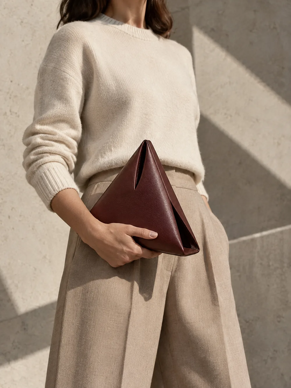 Apex Triangle Clutch in oxblood worn with a tailored outfit