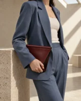Foldnote Clutch in oxblood worn with a tailored outfit