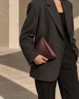 Edgework Triangle Clutch in oxblood worn with a tailored outfit