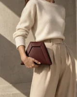 Inlet Trapezoid Clutch in oxblood worn with a tailored outfit