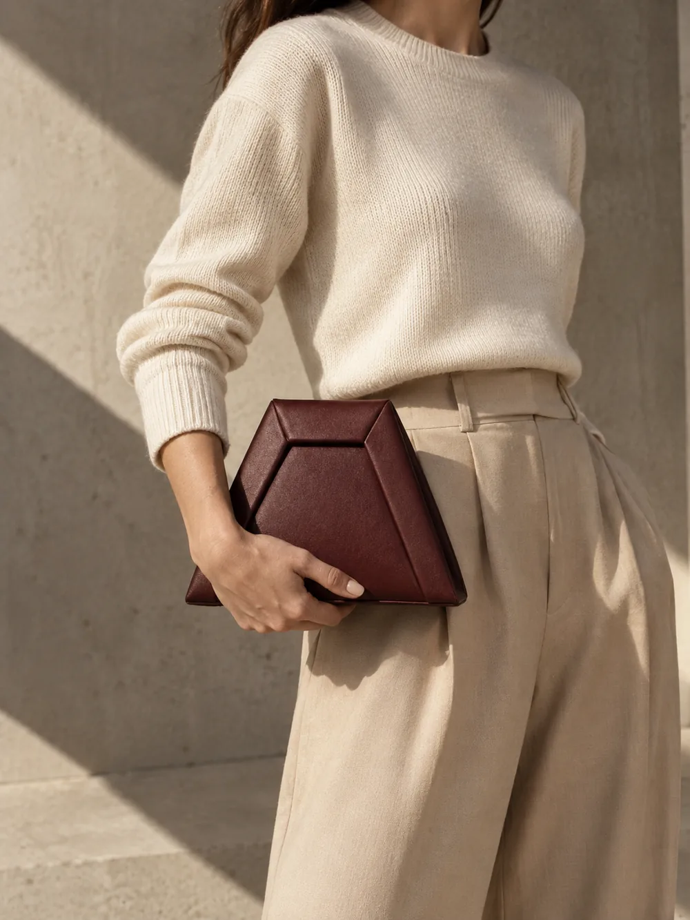 Inlet Trapezoid Clutch in oxblood worn with a tailored outfit