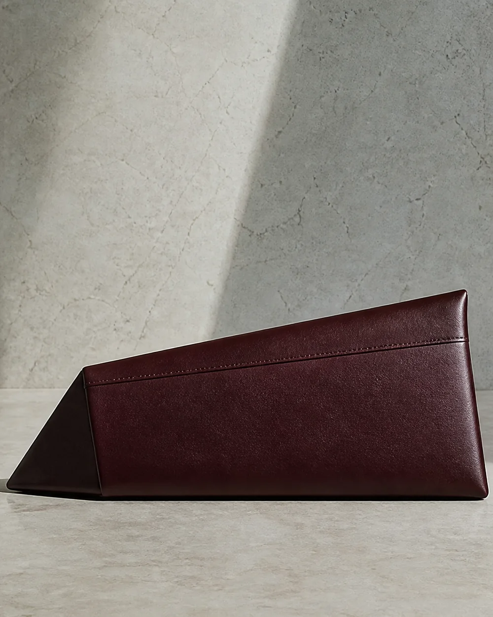 Lucent Wedge Clutch in oxblood, back view