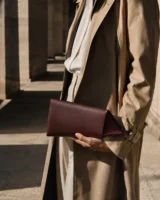 Lucent Wedge Clutch in oxblood worn with a tailored outfit