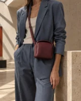 Portico Arch Crossbody in oxblood worn with a tailored outfit