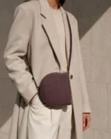 Orbit Crossbody in plum worn with a tailored outfit