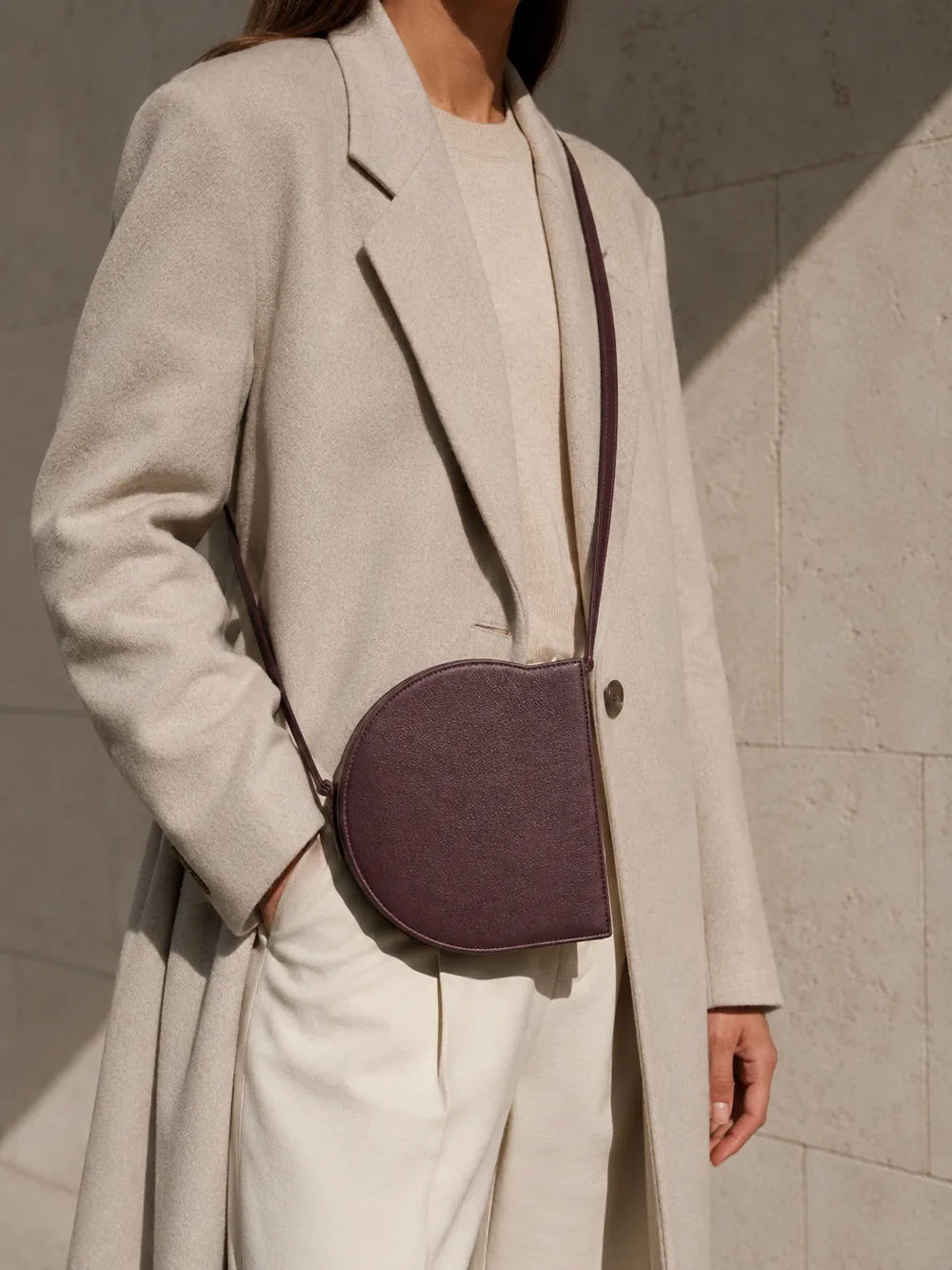 Orbit Crossbody in plum worn with a tailored outfit