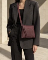 Angle Nested Crossbody in plum worn with a tailored outfit
