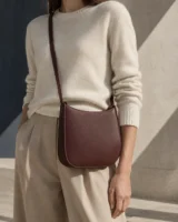 Silhouette Crossbody in oxblood worn with a tailored outfit