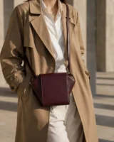 Graft Crossbody in plum worn with a tailored outfit