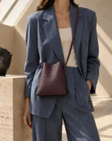Lantern Crossbody in plum worn with a tailored outfit