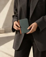 Foldbook Wallet in teal worn with a tailored outfit
