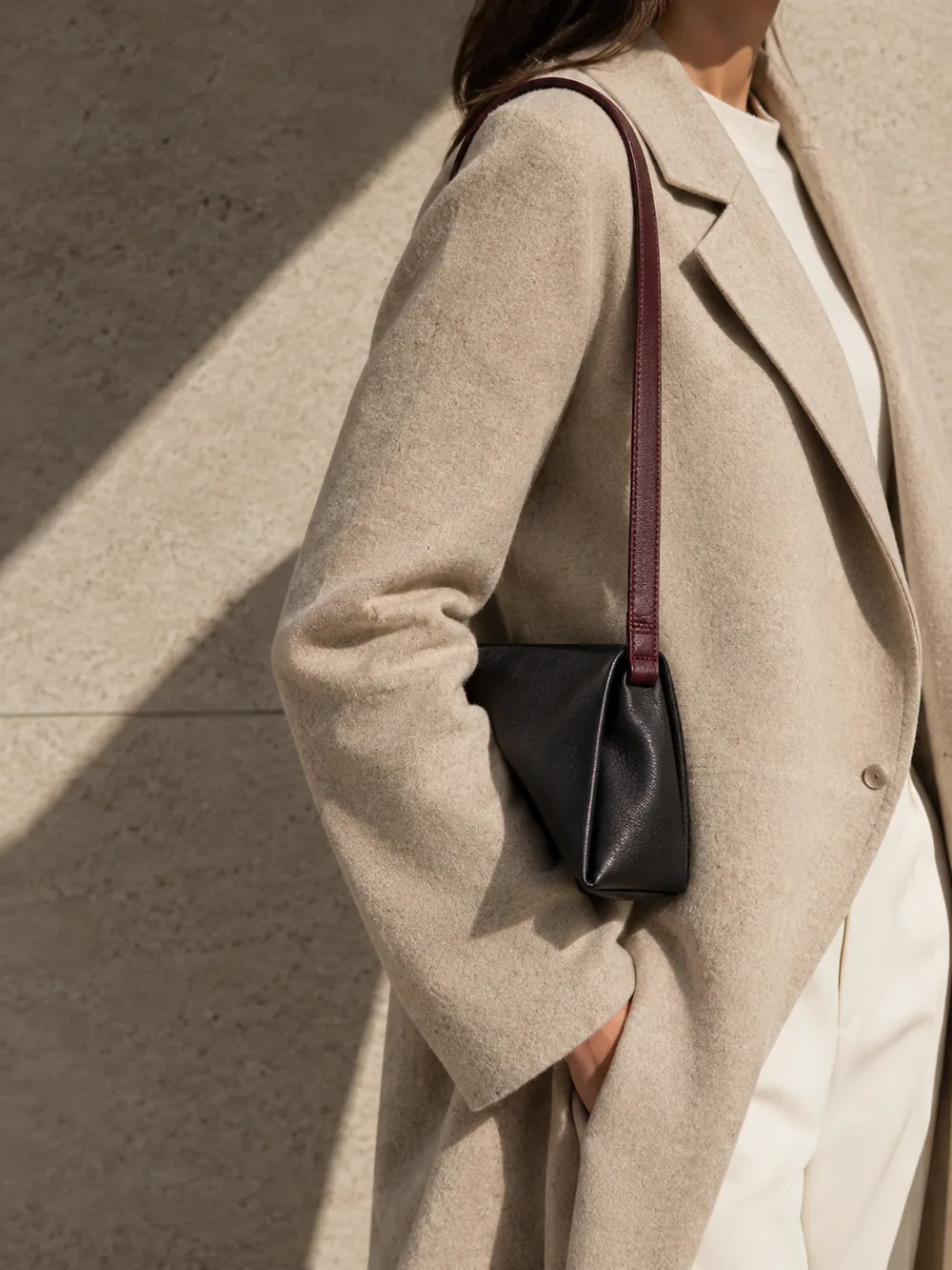 Continuity Strap in oxblood worn with a tailored outfit